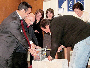 Left to right: Mayor Joseph Curtatone, David Pignone and Sal Querusio work to open a time capsule removed from the cornerstone of the former Saint Polycarp School. Looking on are Ursula Salerno, Meridith Levy and Camille Long. ~Photo by Elizabeth Sheeran