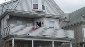 Neighbors of Officer Collier drape a flag off their porch Friday. ~Photo by Bobbie Toner