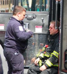  Firefighter Tom Ross is treated for a facial laceration by an EMT from Cataldo Ambulance during the fire.  ~Photo by Somerville Fire Department.