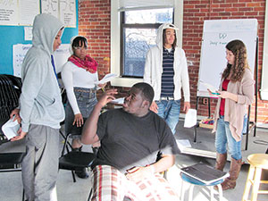 Working on a sketch for this Saturday’s Peace Month kick-off show are (left to right) youth organizers Joshua Ojo, Judcine Felix, Duvy Norestant (seated) and Manny Rivera and program coordinator Emily Parrott. ~Photo  by Elizabeth Sheeran