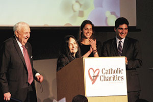 Marshall Sloane, left, of Century Bank smiles towards his wife, Barbara, as she speaks about receiving the Justice and Compassion Award as their grandchildren, Rachel and Joshua, look on during Catholic Charities Annual Spring Celebration at the JFK Library and Museum in Boston Wednesday, May 15. ~ Photos by Rebecca Comella/Catholic Charities of Boston 