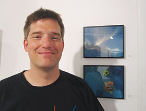 Ted Ollier, one of several “lo-fi” photographers exhibiting at the Washington Street Art Center show, proudly stands before his works on display. ~Photo by Douglas Yu 